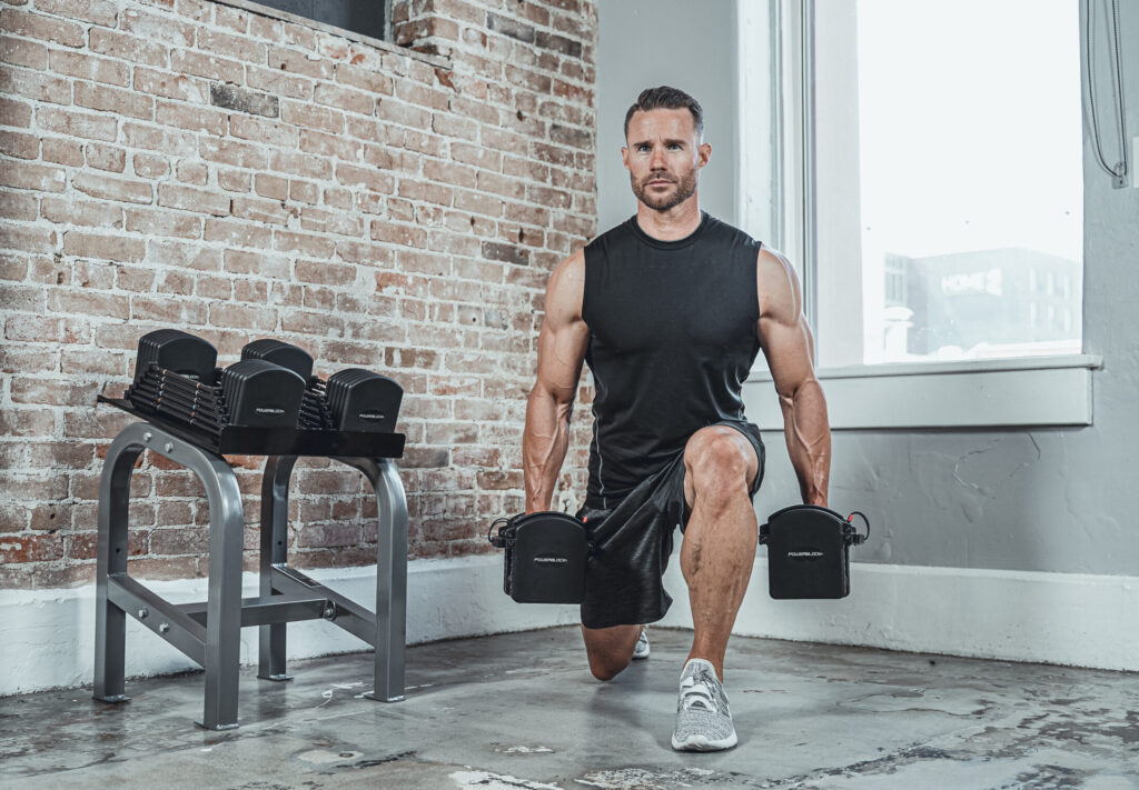 Man lunging with PowerBlock dumbbells