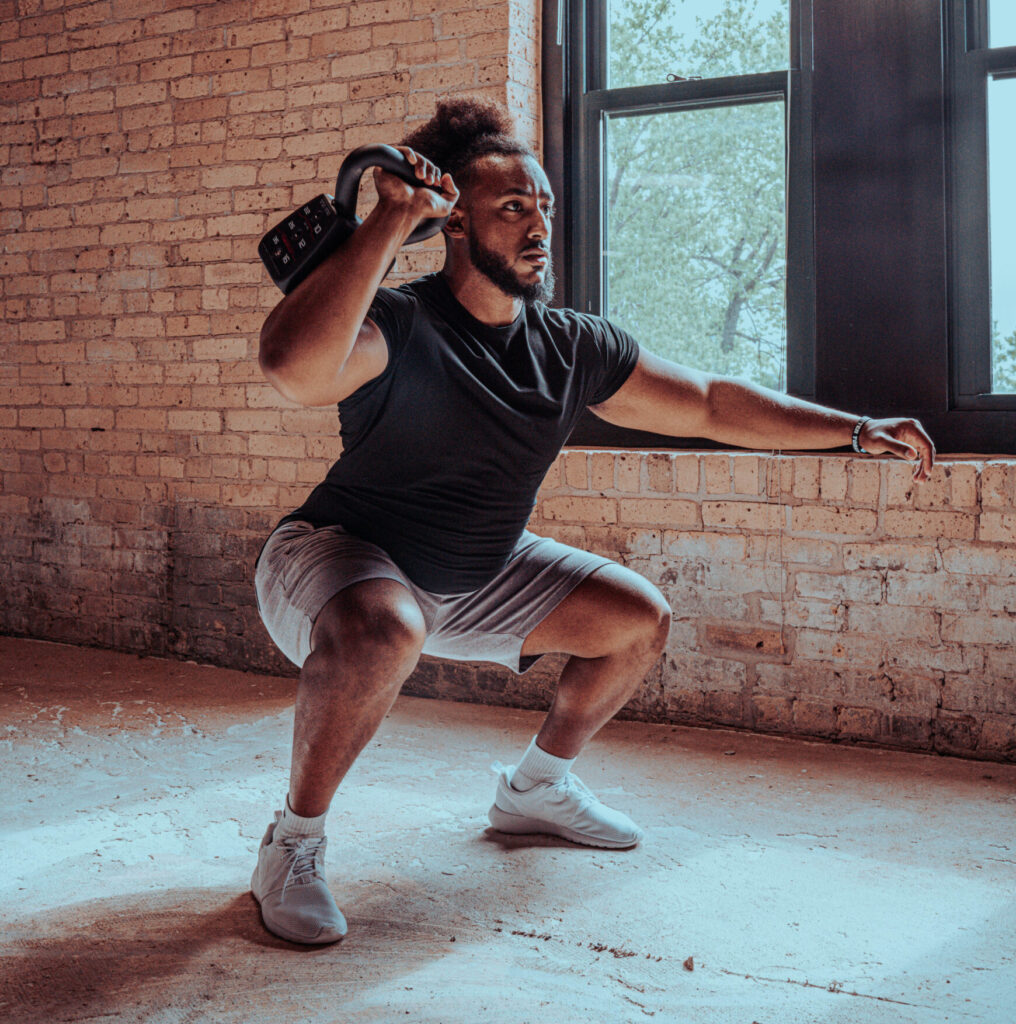 Man performing a squat with a kettlebell